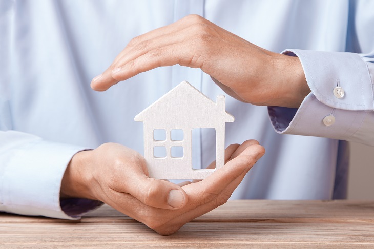 Hands covering house